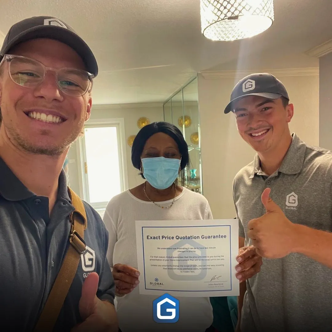 Two men giving thumbs up and smiling, standing with a woman wearing a face mask holding a certificate titled 'Exact Price Quotation Guarantee' inside a home.